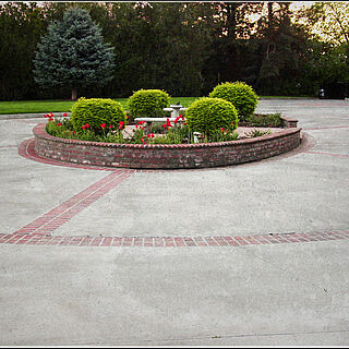 Round about circular driveway with custom brickwork with landscaping in the middle
